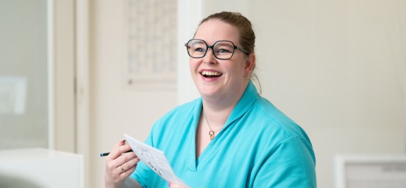 Fr. Lange lacht während sie an der Rezeption arbeitet