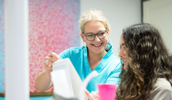 Fr. Lang erklärt einer Patientin etwas während einer Behandlung